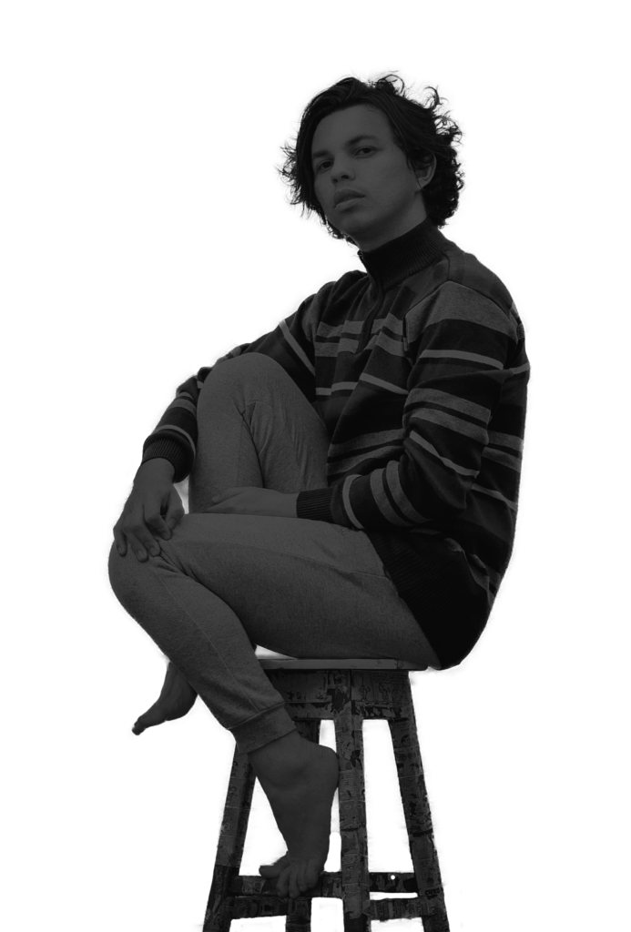 Schattenbild von Deniz, ein junger, transidenter Mann auf einem Barhocker sitzend mit angezogenem Knie